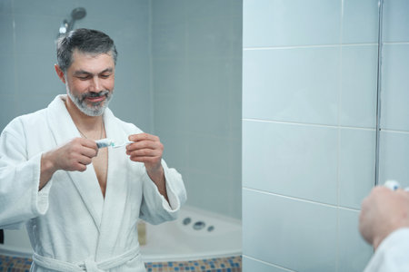 Man getting ready to brush teeth in hotelの写真素材