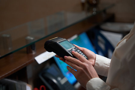 Administrator holding in hands and checking payment terminal