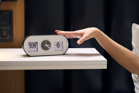 Electronic alarm clock shows time, date and day of week