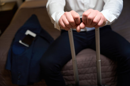 Male holding the handle of suitcase in the hostelの写真素材