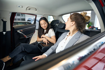 Two happy women at back seats in carの写真素材