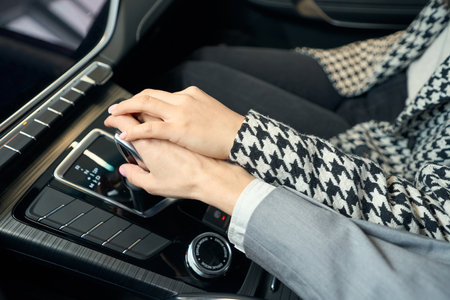 Two womens hands in suits on automobile gearboxの写真素材