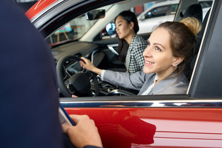 Happy woman looking at someone from drivers seat