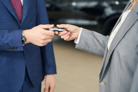 Business people in suits holding car key in handsの写真素材