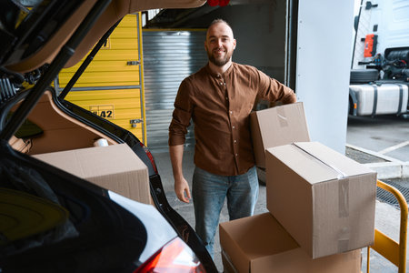 Smiling young man holding a box in his hand