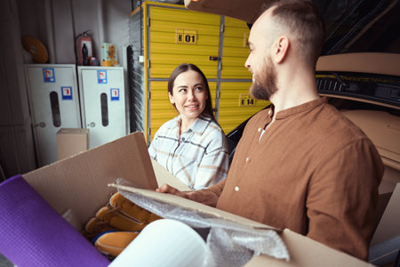 Pleasant lady looking at an adult man with merchandise
