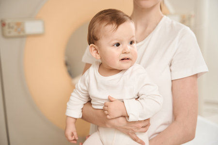 Parent with baby next to CT scanner in clinic