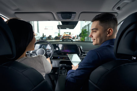 Young woman in the drivers seat chats cutely witha man