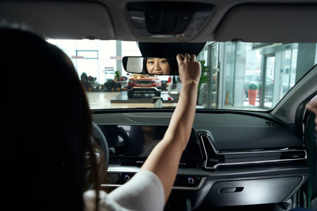Young asian woman sits in the drivers seatの写真素材