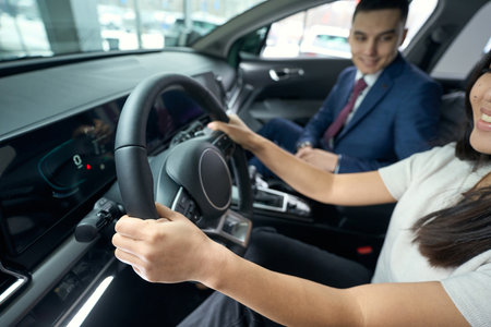 Happy woman sits behind the wheel in the drivers seat