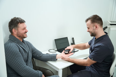 Bearded man in a medical center undergoes oligoscan diagnostic procedure