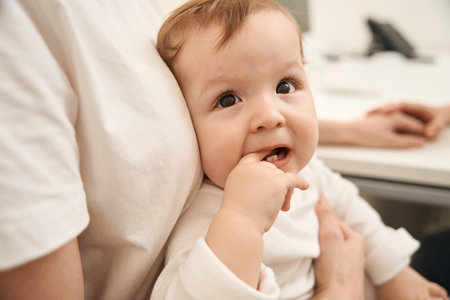 Little child touching upper tooth with finger during medical consultation