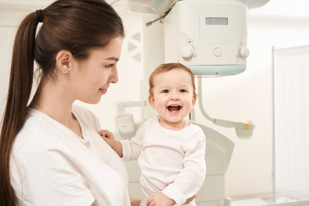 Young mom and joyful infant before radiography procedureの写真素材