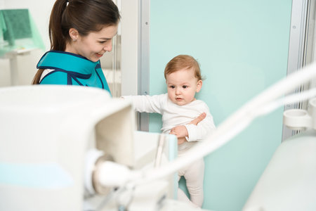Little baby undergoing radiography procedure in presence of motherの写真素材