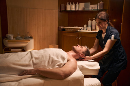 Experienced osteopath performing manipulation of cervical spineの写真素材