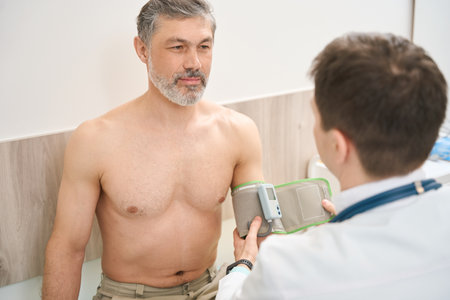 Cardiologist putting on tonometer on patient handの写真素材