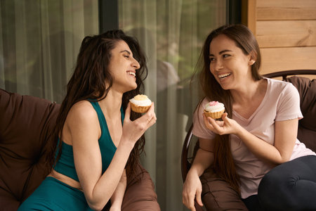 Happy women relaxing on chair and communicateの写真素材