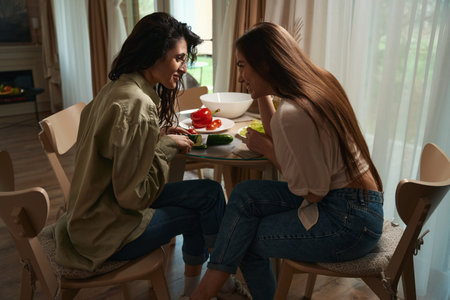 Female friends spend time at table in the kitchenの写真素材