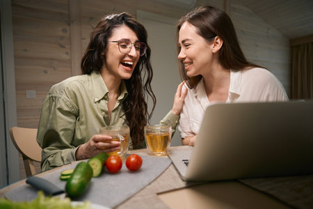 Young friends watching movie on computer and communicatesの写真素材