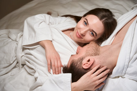 Pleased female resting with her companion in bedroomの写真素材
