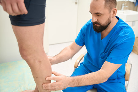 Physician looking patient legs in the clinicの写真素材
