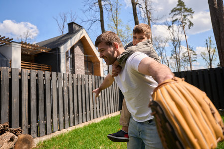 Caucasian man plays with a child near his houseの写真素材