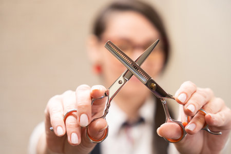 Female holds hairdressing scissors in her handsの写真素材