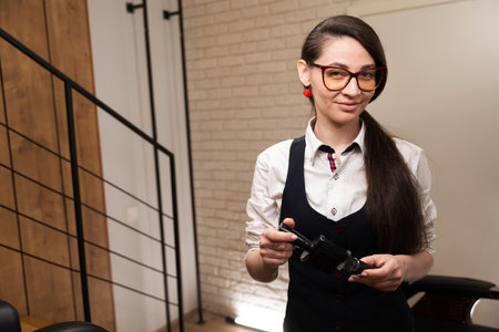 Barber woman cleaning clipper with special brushの写真素材