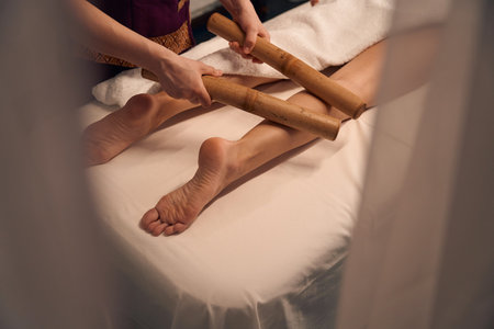 Wellness center masseuse giving leg massage to femaleの写真素材