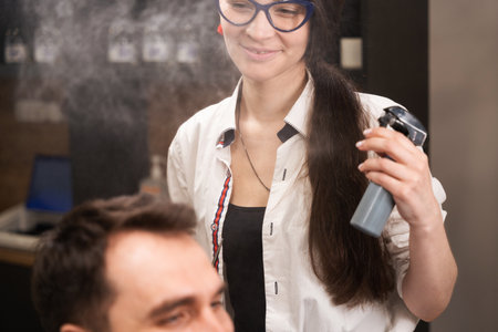 Pretty woman in glasses is styling the clients hairの写真素材