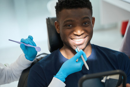 African American man with dental explorer in his mouth smilingの写真素材