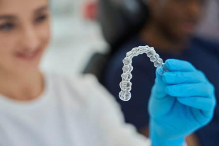 Dental technician holding invisible braces, or clear alignersの写真素材