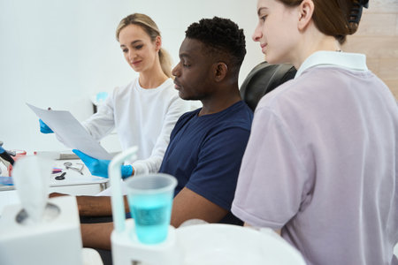 Stomatologist showing to African American client x-ray image of his jawの写真素材