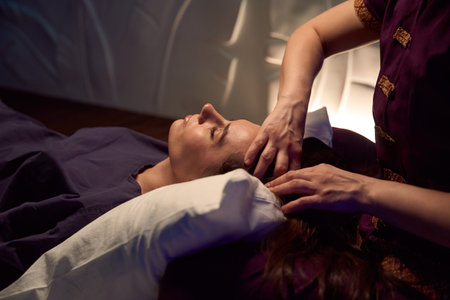 Woman receiving relaxing head massage in wellness centerの写真素材