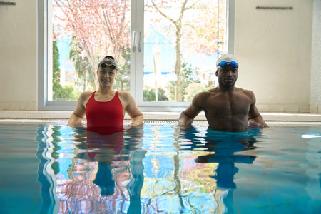 Two swimmers posing for camera in water before swimming workoutの写真素材