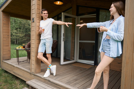 Happy couple standing on terrace of cottage house