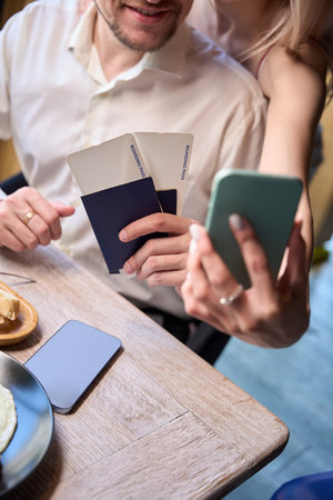 Happy couple making photo for social networks holding boarding passes