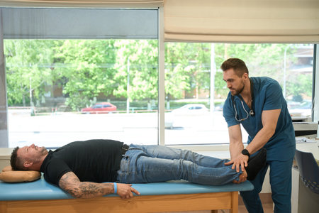 Physical therapist assessing lower extremity muscle strength in patient