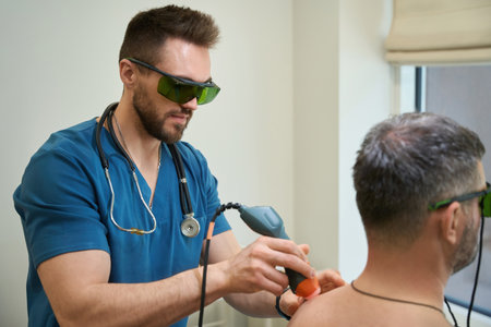 Professional physiotherapist is treating adult man for dorsodynia