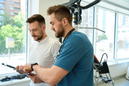 Rehabilitation center physiotherapist and fitness coach developing training planの写真素材