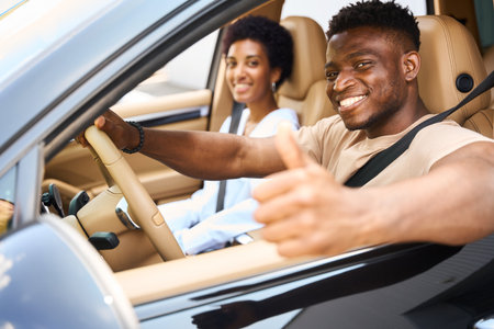African American guy and girlfriend are sitting in the carの写真素材