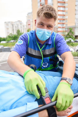 Ambulance officer fixes the patient on a special stretcherの写真素材