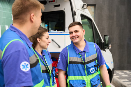 Paramedics and a nurse communicate in a parking lotの写真素材