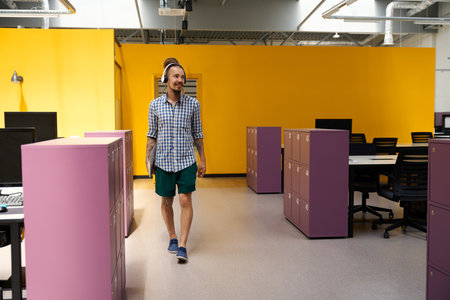 IT specialist with beard and mustache enters room with pink lockersの写真素材