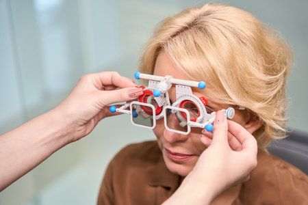 Specialist ophthalmologist at workplace working with patientの写真素材