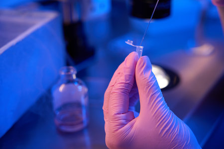 Embryologist in gloves transferring samples to cryotube, cryopreservationの写真素材