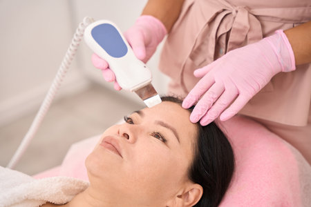 Beautiful woman undergoing ultrasonic facial cleansing in a cosmetology salon