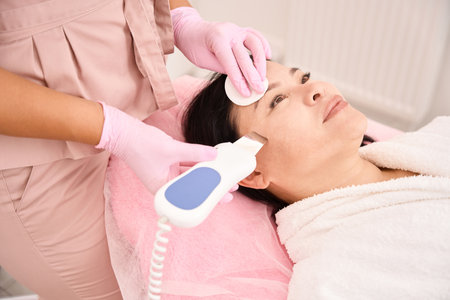 Ultrasonic facial cleansing procedure in a cosmetology salon