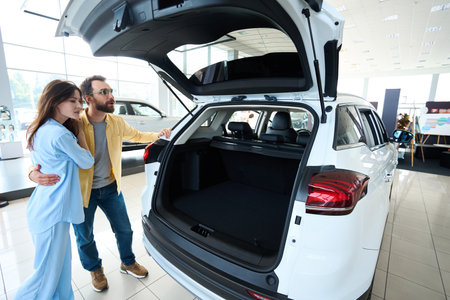 Beautiful couple choosing auto in car dealershipの写真素材