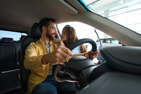 Young couple choosing auto in car showroom